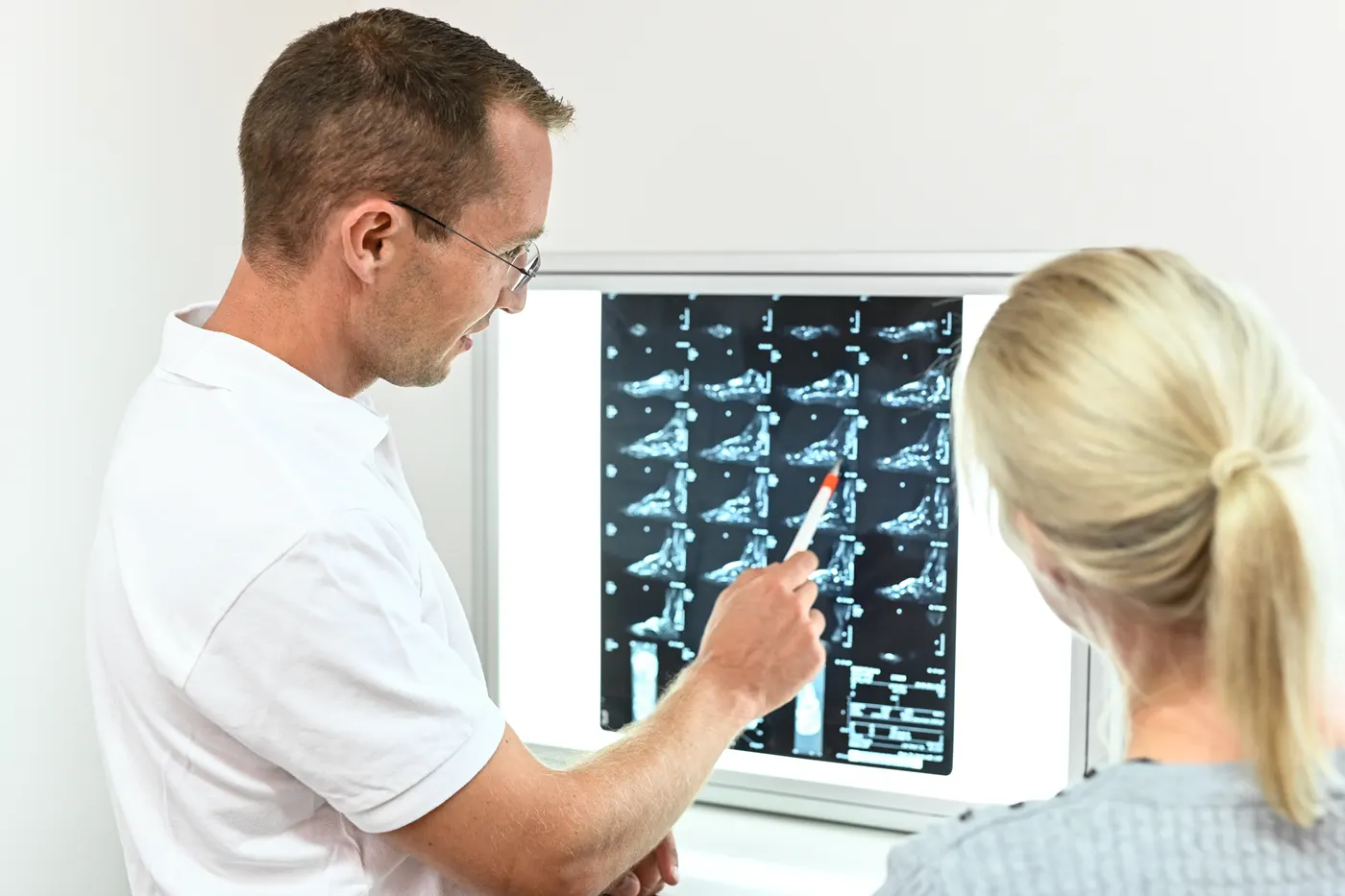 Priv.-Doz. Dr. Lukas Zak bespricht Röntgenbilder mit einer Patientin